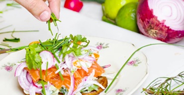 someone garnishing a salad with cilantro